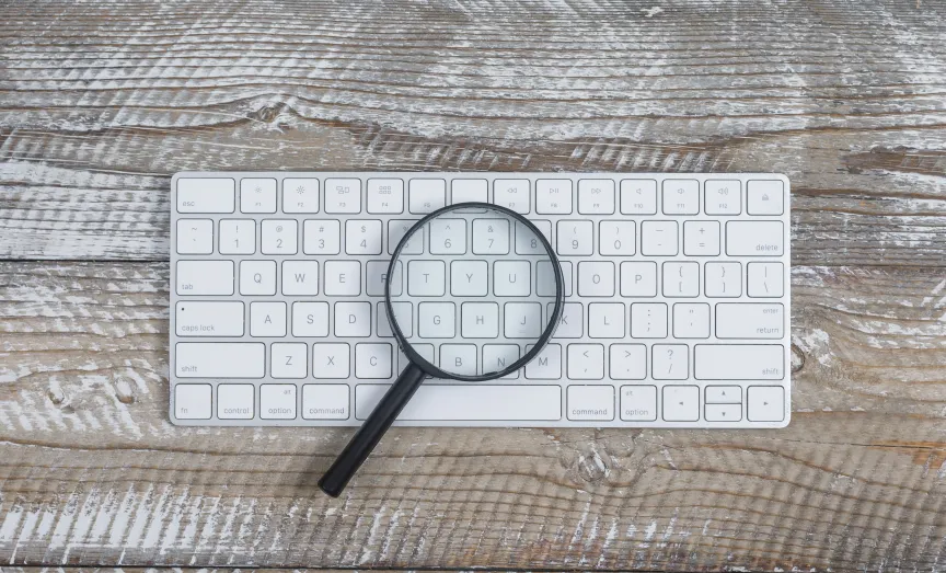 Photo d'une loupe posée sur un clavier d'ordinateur